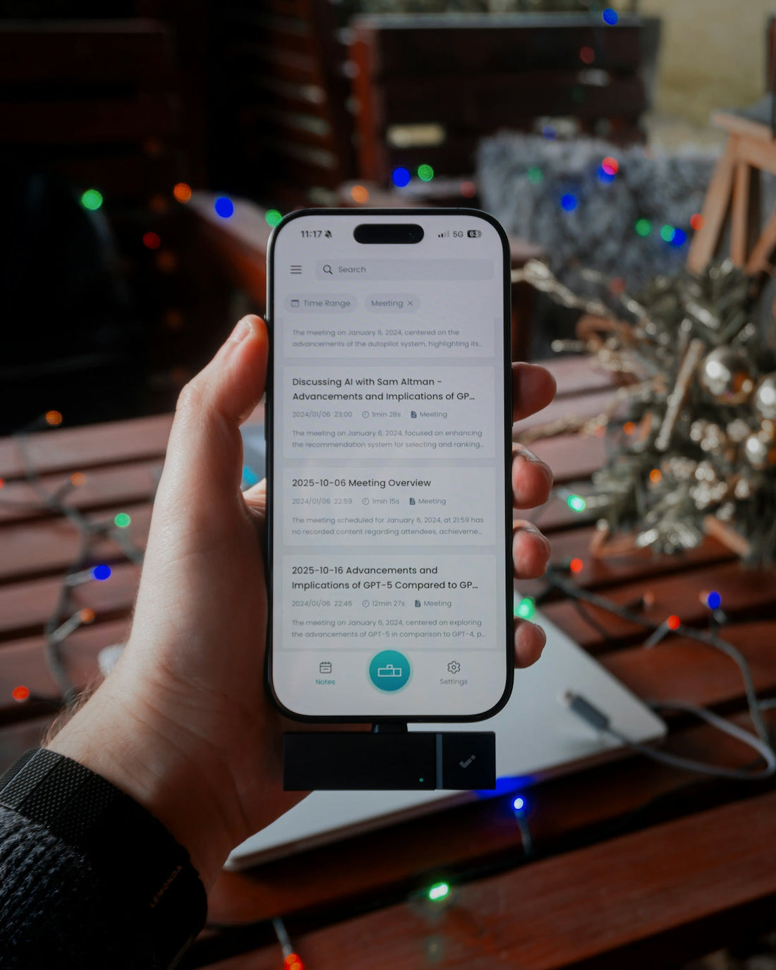 Hand holding a smartphone with a list on screen.